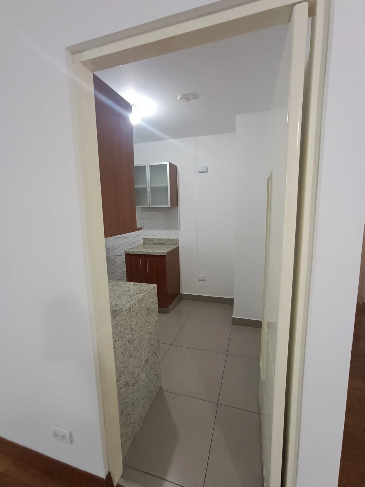 Cocina con muebles de madera oscura y mesada de granito