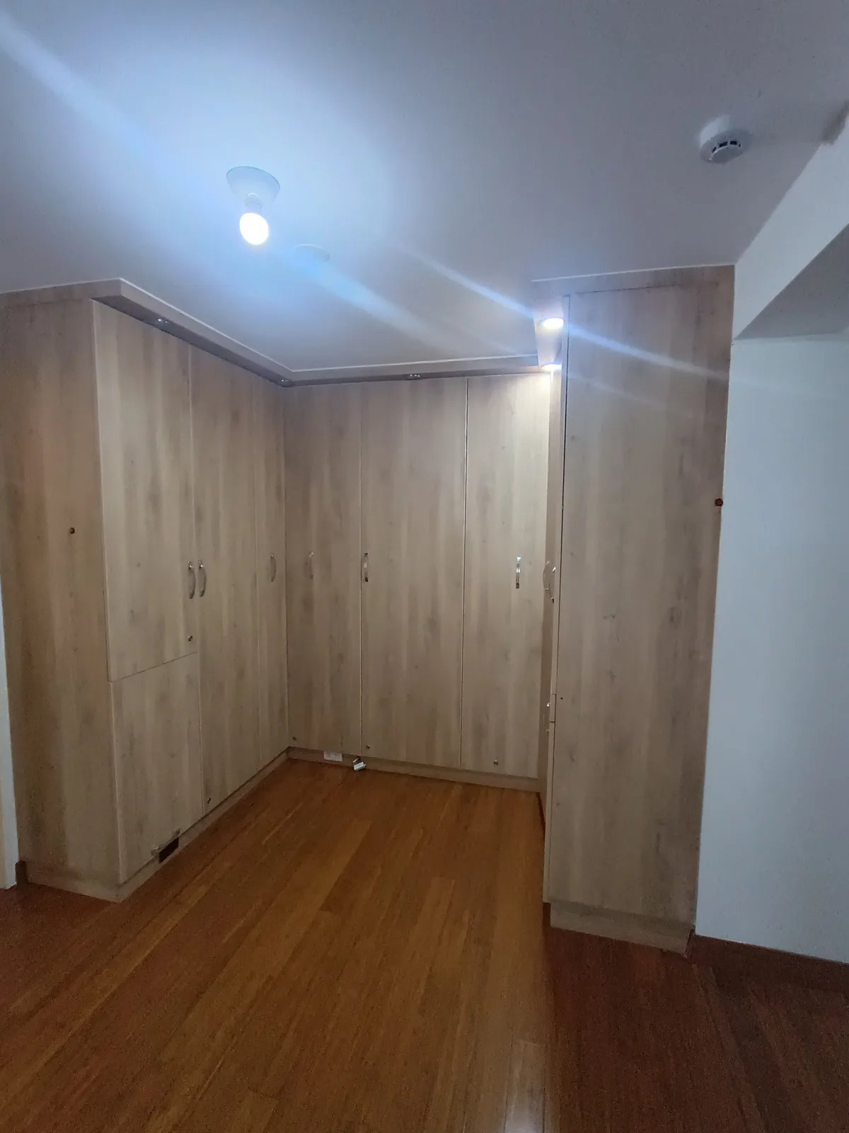 Vestidor con closets empotrados piso a techo en madera natural